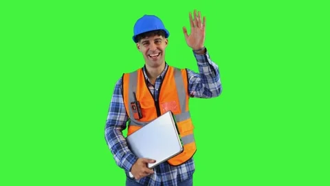 Smiling construction engineer waving at the camera while holding laptop, we.. Stock Footage 286985854