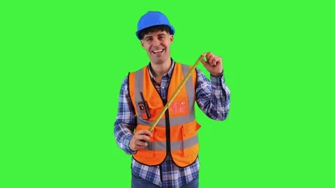 Smiling construction worker holding a tape measure, wearing orange vest and.. Stock Footage 286985927
