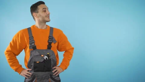 Smiling Construction worker looking to the side, presenting invisible product Stock Footage 143596351