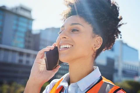 Smiling Construction Worker on Phone Call in Cityscape Stock Photos