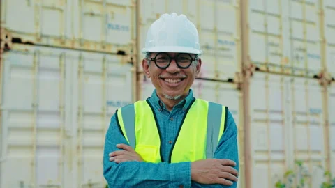 Smiling Construction Worker in Safety Gear Stands Confidently Near Shipping Stock-Footage 306186038
