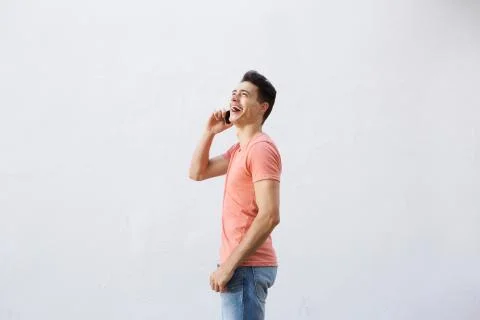 Smiling cool guy walking and talking on mobile phone Stock Photos
