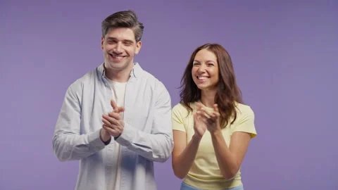 Smiling couple applauding with enthusiasm while looking at camera. Claps hands Stock Footage 341700787