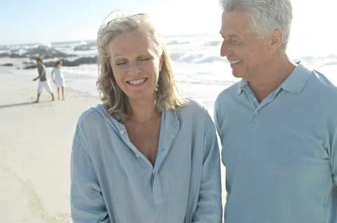 Smiling couple on the beach, another couple in background Stock Photos