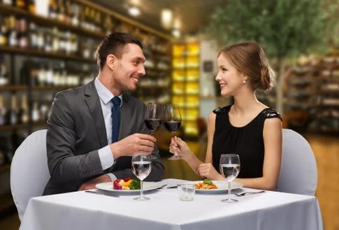 Smiling couple clinking wine glasses at restaurant Stock Photos