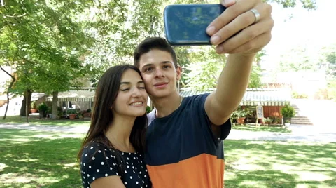 Smiling couple doing selfie on smartphone in the part, slow motion 1 Stock-Footage 68485199