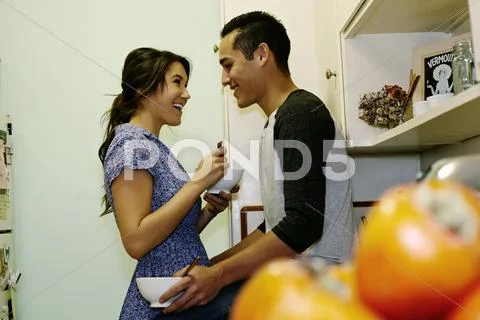 Smiling couple eating cereal in kitchen Stock Photos