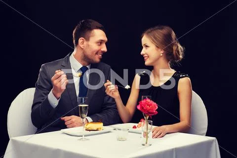 Smiling couple eating dessert at restaurant Stock Photos