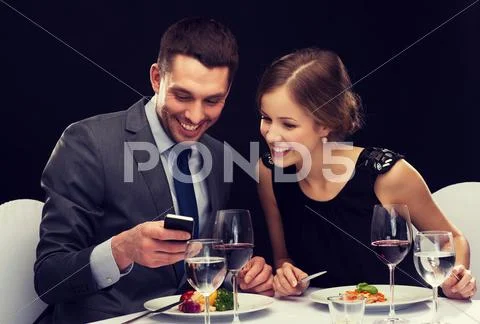 Smiling couple eating main course at restaurant Stock Photos