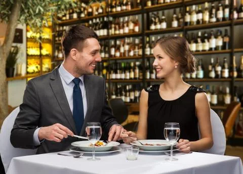 Smiling couple eating main course at restaurant Stock Photos