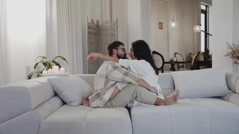 Smiling couple embracing while sitting on sofa Stock Footage 261506812