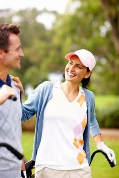Smiling couple on golf course. Smiling couple standing on golf course and Fotos de archivo