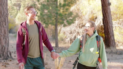 Smiling Couple Hand in Hand walking on a Forest Hiking Trail Stock Footage 263157267