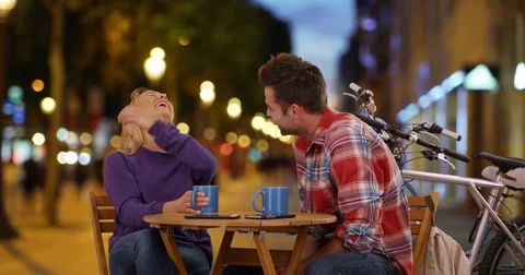 Smiling couple having coffee on the Champs-Elysees at night Stock Footage 85332397