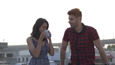 Smiling couple having fun together while talking to each other standing outdoor. Video stock 148978300
