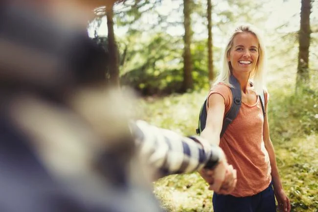 Smiling couple holding hands hiking in woods Stock Photos
