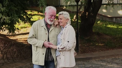 Smiling couple holding hands by tree Stock Footage 168910713
