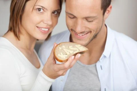 Smiling couple holding a slice of bread and cheese Stock Photos