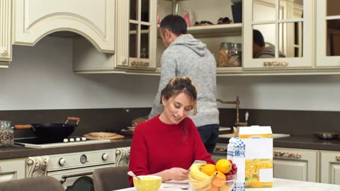 A smiling couple on a kitchen. Man removing a cup of tea from the table. Woman Stock Footage 145141828