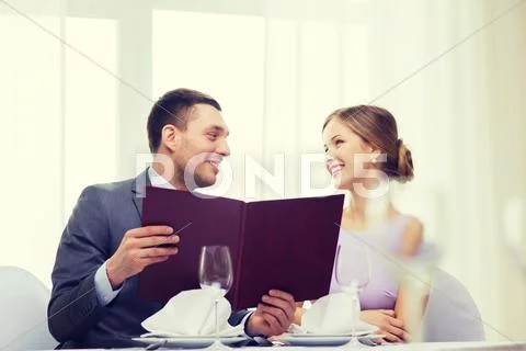 Smiling couple with menu at restaurant Stock Photos