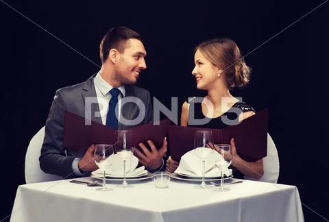 Smiling couple with menus at restaurant Stock Photos