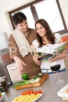 Smiling couple in modern kitchen cook together Stock Photos