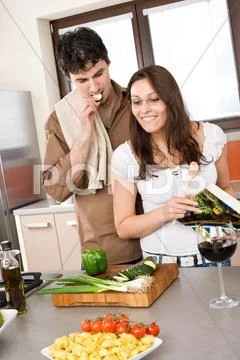 Smiling couple in modern kitchen cook together Stock Photos