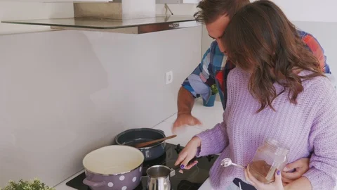 Smiling couple preparing cup of coffee in the kitchen 스톡 동영상 99399139