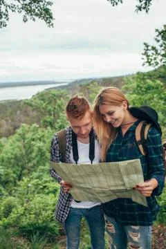 Smiling couple reading map while hiking in forest Fotos Stock