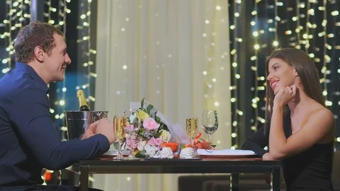 Smiling couple spends evening time sitting in cafe 스톡 동영상 125758003