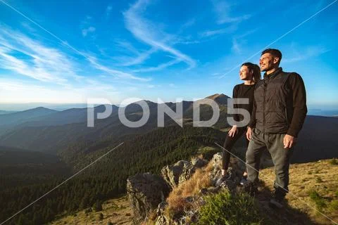 The smiling couple standing on the beautiful mountain landscape background Stock Photos