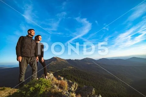 The smiling couple standing on the beautiful mountain landscape background Stock Photos