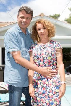 Smiling Couple standing in front of newly owned house Stock Photos