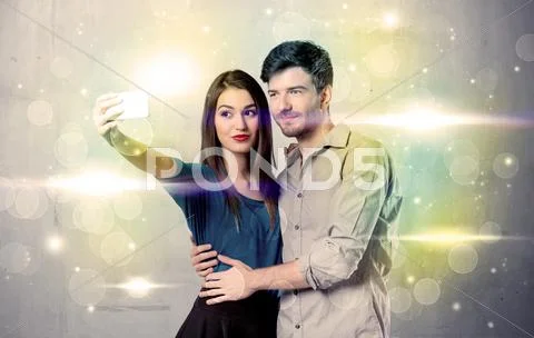 Smiling couple taking selfie in glitter light Stock Photos