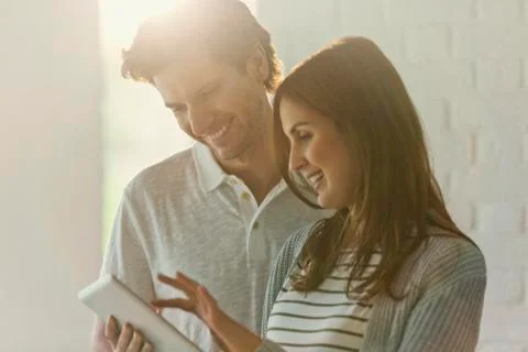 Smiling couple using digital tablet Stock Photos