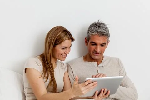 Smiling couple using the ipad Фото