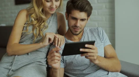 Smiling couple using tablet at home Stock Footage 68721044