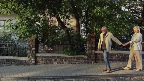 Smiling couple walking together by retaining wall Stock Footage 168910928