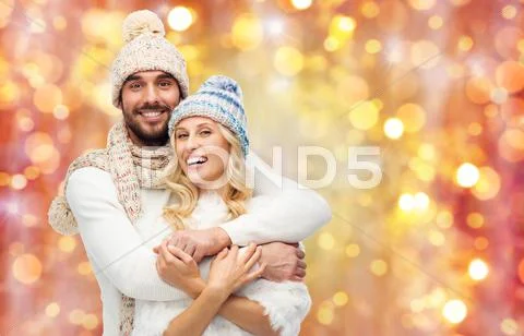 Smiling couple in winter clothes hugging Stock Photos