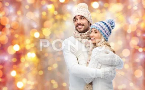 Smiling couple in winter clothes hugging Stock Photos