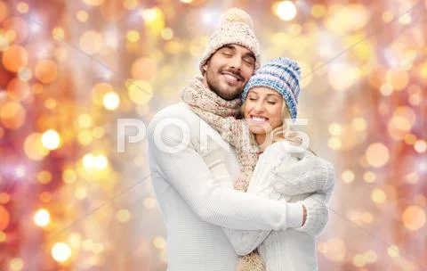 Smiling couple in winter clothes hugging Stock Photos
