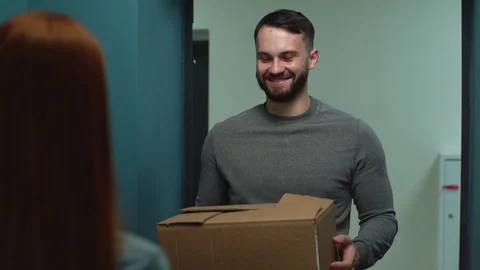 Smiling courier man delivering parcel to woman client on doorstep at apartment Video stock 146592714