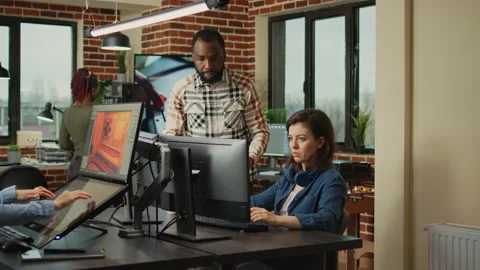 Smiling coworker talking to 3D developer about digital art production Stock Footage 229819385