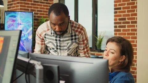 Smiling coworker talking to 3D developer about digital art production Stock Photos