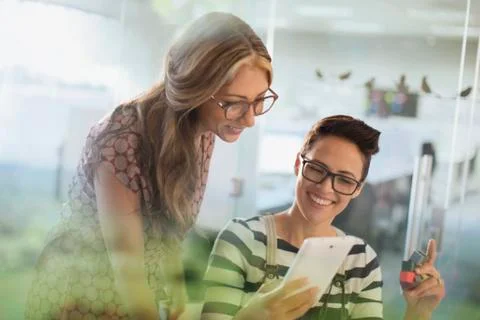 Smiling creative businesswomen with prototype using digital tablet Foto stock