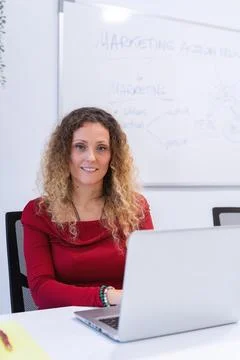 Smiling Curly-Haired Professional at Work 스톡 사진