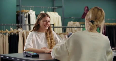 Smiling customer interacting at clothing store checkout Stock Footage 321607576