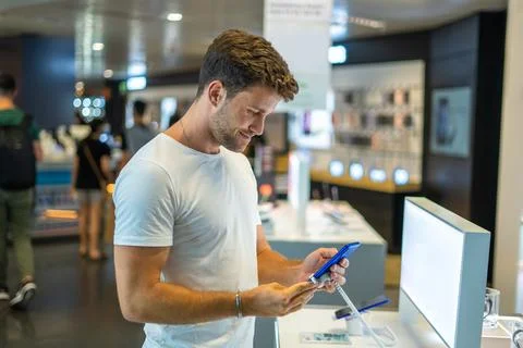 Smiling customer testing smartphone in store Stock Photos