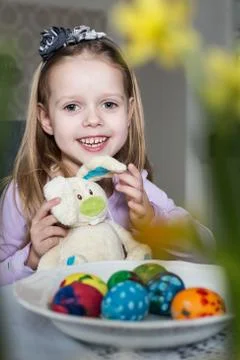 Smiling cute child with easter eggs and plush bunny. Easter, holiday Stock Photos