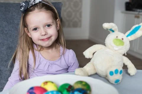 Smiling cute child with easter eggs and plush bunny. Easter, holiday Stock Photos